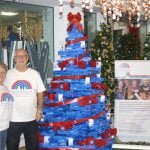 Mary and her husband from Francis House stood with the Midshire donation to the Festival of Christmas Trees